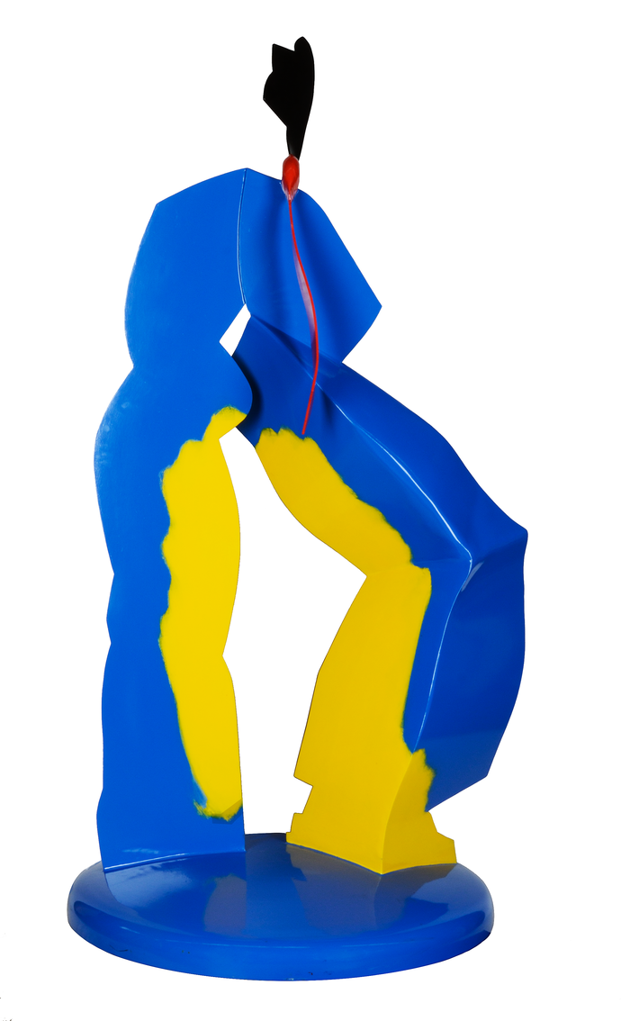 Abstract sculpture in blue and yellow, featuring irregular shapes and a black form rising from the top, set on a round base.