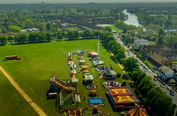 An aerial image of a funfair on green grass