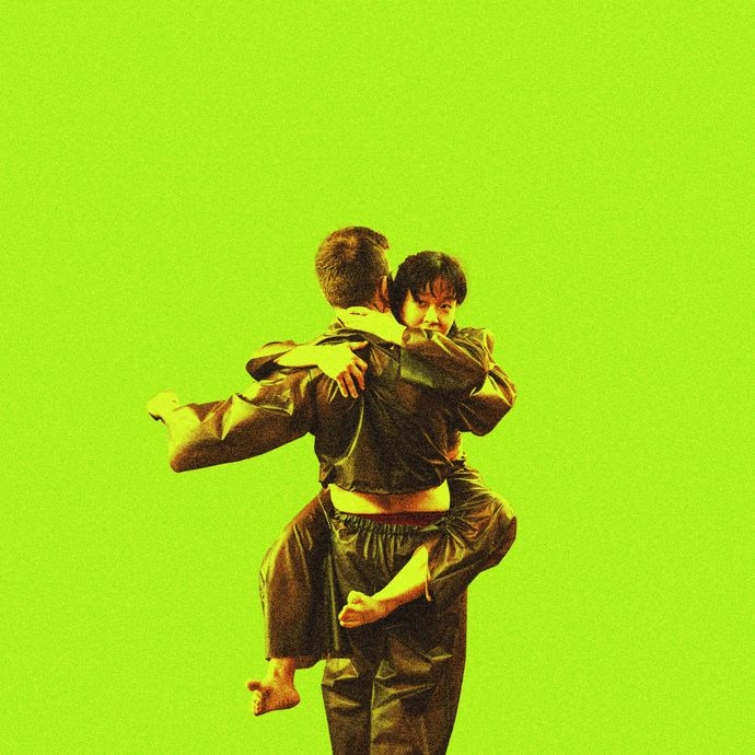 2 dancers wrapped in one another in front of a lime green background