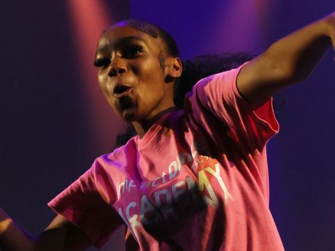 A young female dancing wearing a pink tshirt