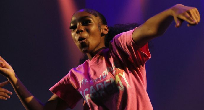 A young female dancing wearing a pink tshirt