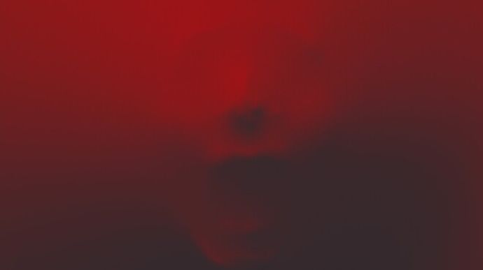 A face pressing against a translucent red surface, creating a distorted and eerie appearance.