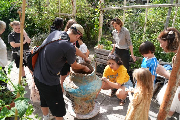 A group of people crafting a object made out of clay