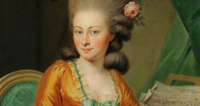 Historical-style portrait of a person wearing an ornate orange dress with green accents and lace trim, seated on a green chair. The hairstyle is voluminous and decorated with a pink rose. A sheet of music rests nearby on a surface draped with green fabric.