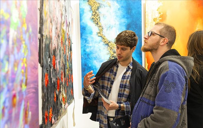 2 individuals looking at art work