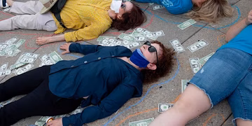 people lying on ground with money notes around them, they have sunglasses and face masks on