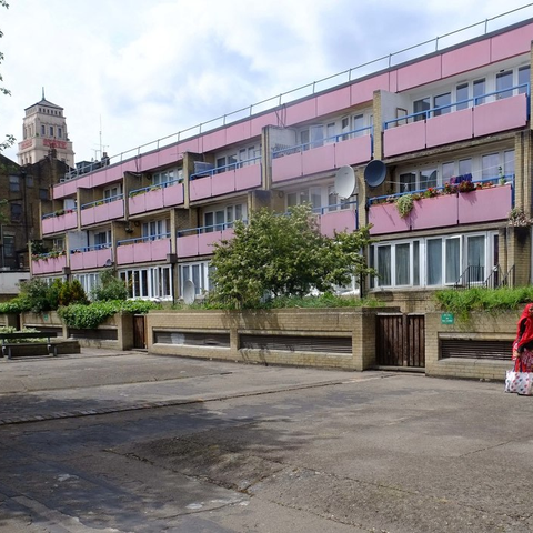 image of housing estate with pink balconies and a tower in the background
