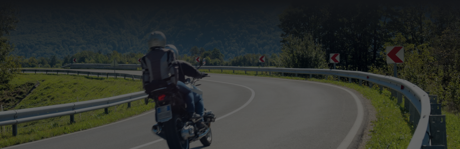 A motorcyclist riding along a winding road.