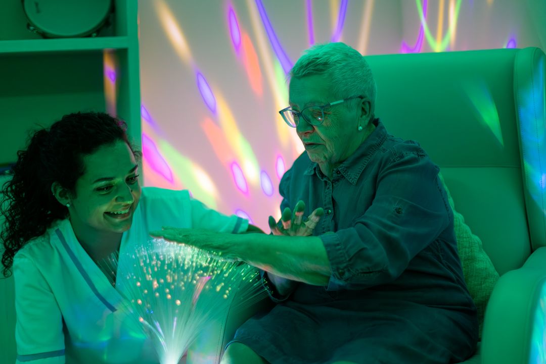 Anciana y cuidadora en sala multisensorial