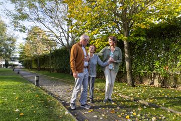 Persona mayor y familiares paseando