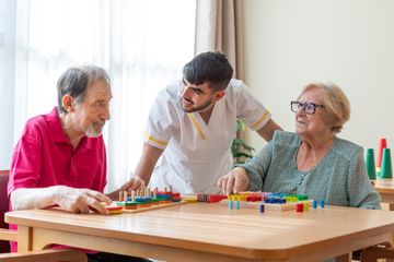 Mayores y cuidadora jugando