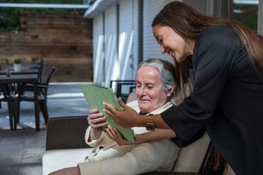 persona mayor y cuidadora con una tablet