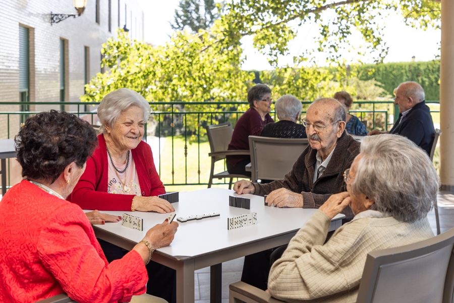 Mayores jugando al dominó en la terraza