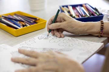 Manos de mayor dibujando en talleres de alzheimer