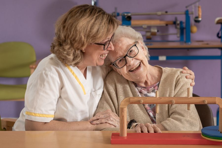 Cuidadora y persona mayor riendose