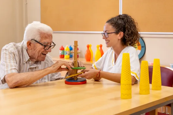 Persona mayor y cuidadora en taller terapéutico