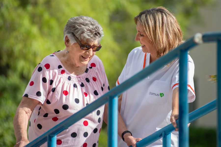 Persona mayor y cuidadora paseando