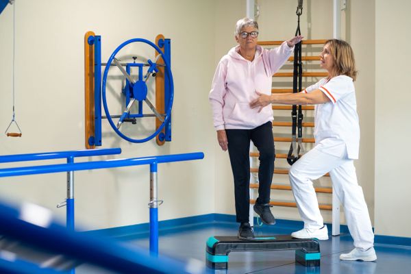 Persona mayor y cuidadora en rehabilitación