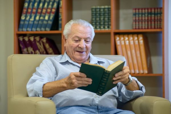 Persona mayor leyendo en la sala de estar