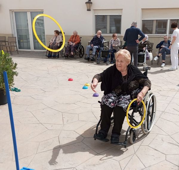 Persona mayor lanzando aros para la actividad psicomotriz