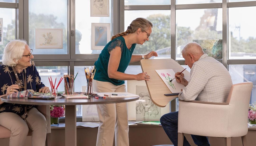 Atelier artistique avec personnes âgées concentrées sur leurs dessins