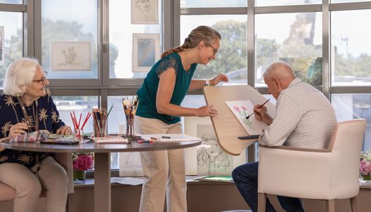 Atelier artistique avec personnes âgées concentrées sur leurs dessins