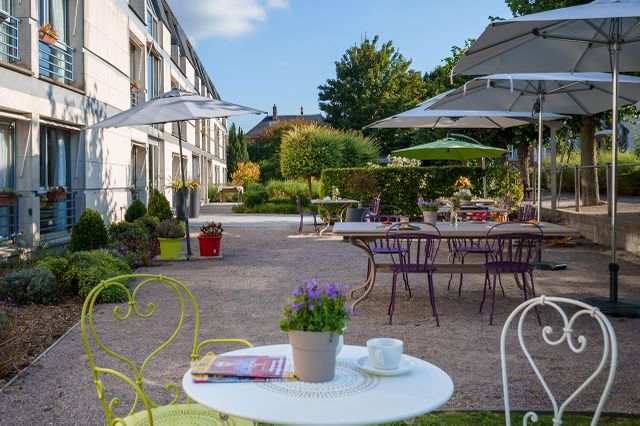 Jardin et salon en terrasse avec parasols en résidence médicalisée seniors à Compiegne, Résidence Tiers Temps