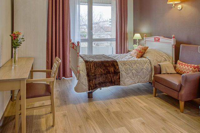 Chambre thème rose poudre maison de retraite Médicis à Sartrouville avec grande baie vitrée et meubles en bois