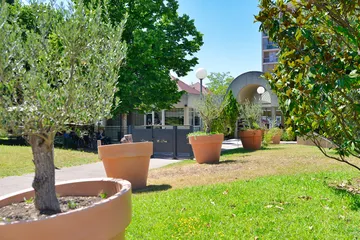 Entrée de maison de retraite chaleureuse avec pots de fleurs à Marseille, Résidence Les Sèolanes