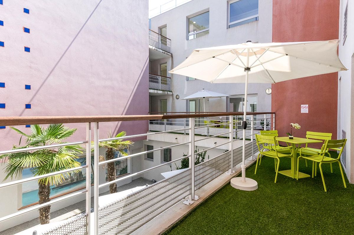 Balcon avec parasol et mobilier exterieur vert, maison de retraite la palmeraie à nice