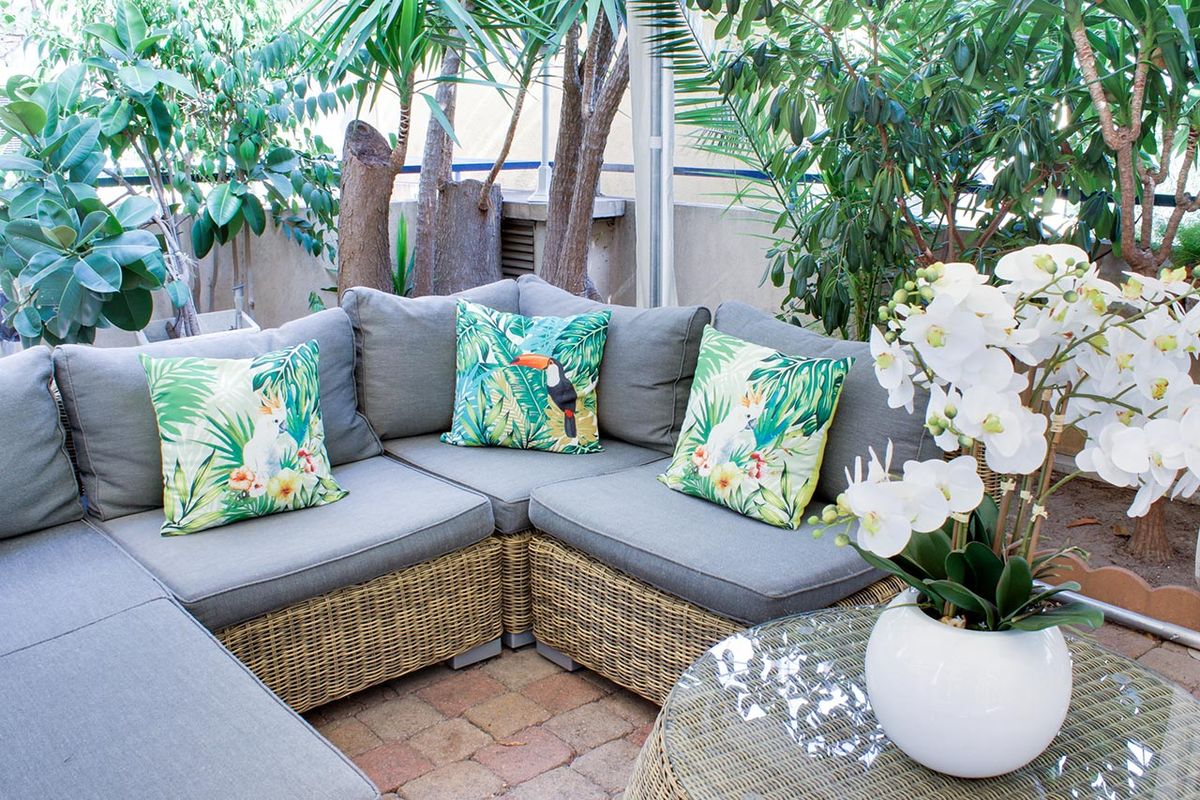 Espace exterieur avec canapé en osier et coussin tropical, résidence bleu soleil à nice
