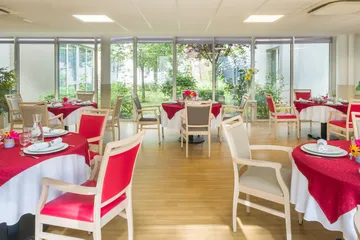 Salle de restauration  illuminée baie vitrée vue cours intérieure avec jardin bucolique