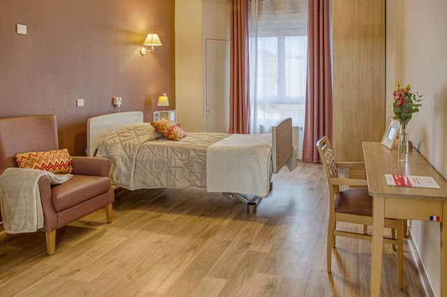 Chambre maison de retraite Médicis à Sartrouville thème rose poudre lumineuse avec meubles bois vintage