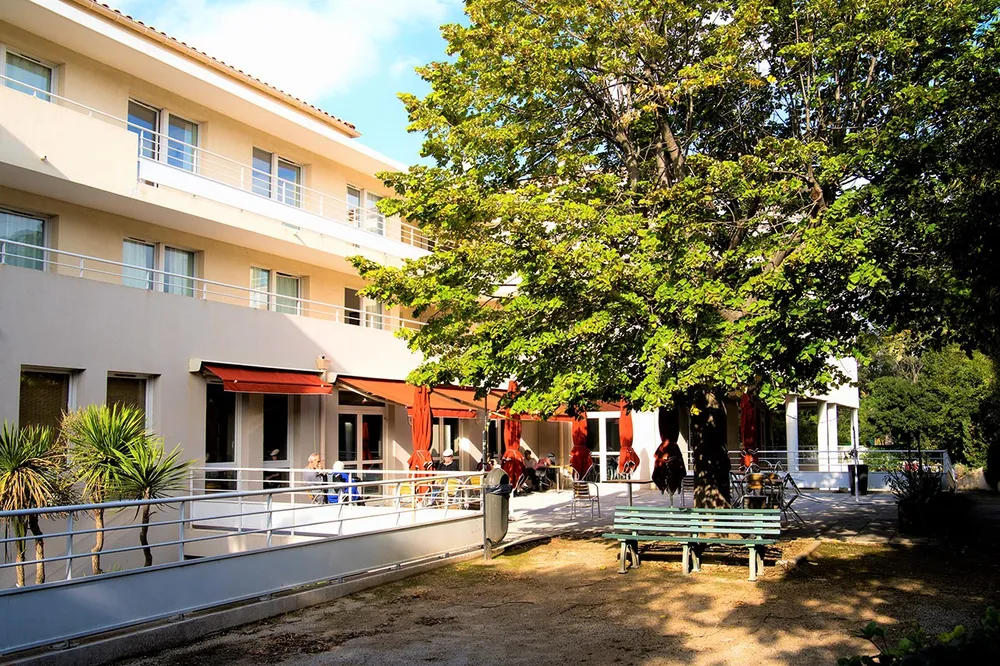 Cour intérieure avec jardin abre et bancs en ehpad à Marseille, Résidence Mazargues