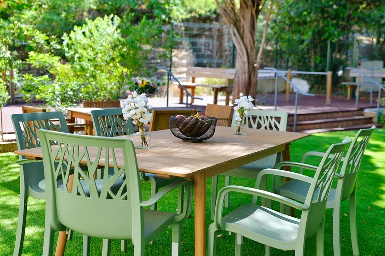 Table de jardin en bois et chaises vertes en maison de retraite à Marseille, Résidence Les Sèolanes