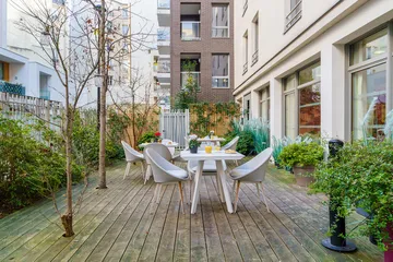Balcon cours intérieure lumineux chaleureux avec végétation et tables Résidence Ornano à Paris