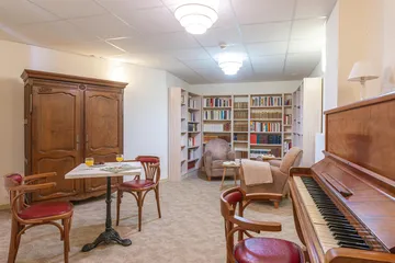 Bibliothèque salle de repos et divertissement avec piano vintage chaleureuse
