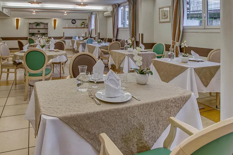 salle de restaurant maison de retraite Médicis à Sartrouville beige et blanc avec fauteil marron et turquoise spacieuse