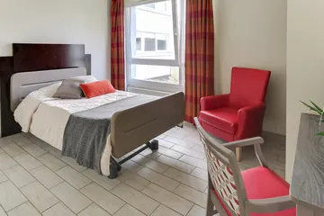Chambre lumineuse Résidence Océane à Paris thème rouge et gris grand lit fauteil rouge