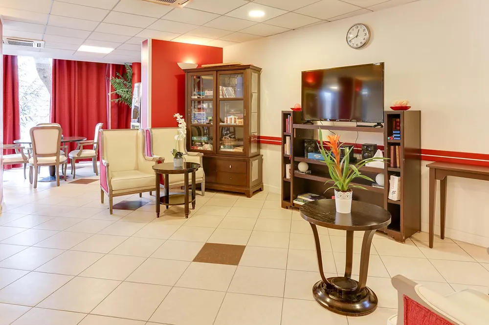 Salon maison retraite Médicis à Argenteuil vintage meubles avec télévision et fauteils beiges, décorée