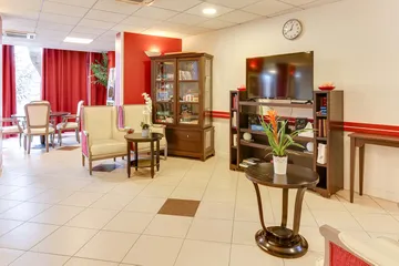 Salon maison retraite Médicis à Argenteuil vintage meubles avec télévision et fauteils beiges, décorée
