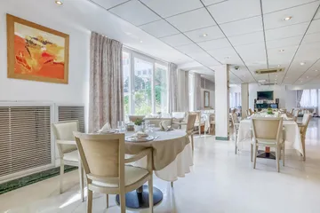 Salle de restaurant lumineuse et moderne avec tables dressées à l'ehpad les marines