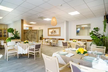 Salle de restauration blanc, avec thème beige et blanc, tables napées et décorées
