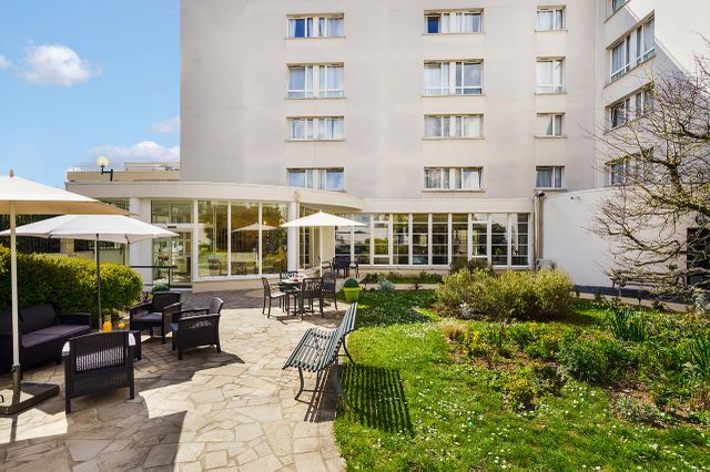 Résidence Les Jardins d'Epinay facade batiment moderne jardin gazon fauteil repos soleil parasol parterre décoré