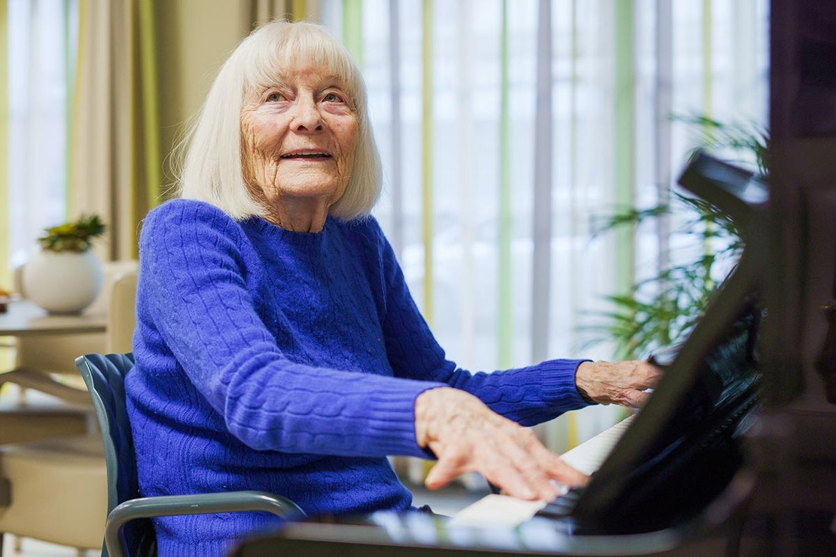 femme senior en pull bleu jouant piano Résidence Ornano à Paris