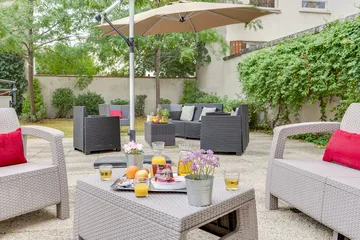 Espace extérieur convivial avec fauteuils et parasol à l’EHPAD Rabelais à Asnières