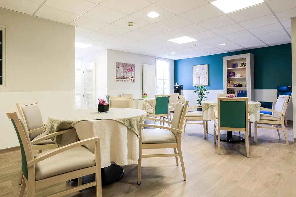 Salon Maison de rertaite Les Jardins Médicis à Pontpoint lumineuse avec tables rondes décorées