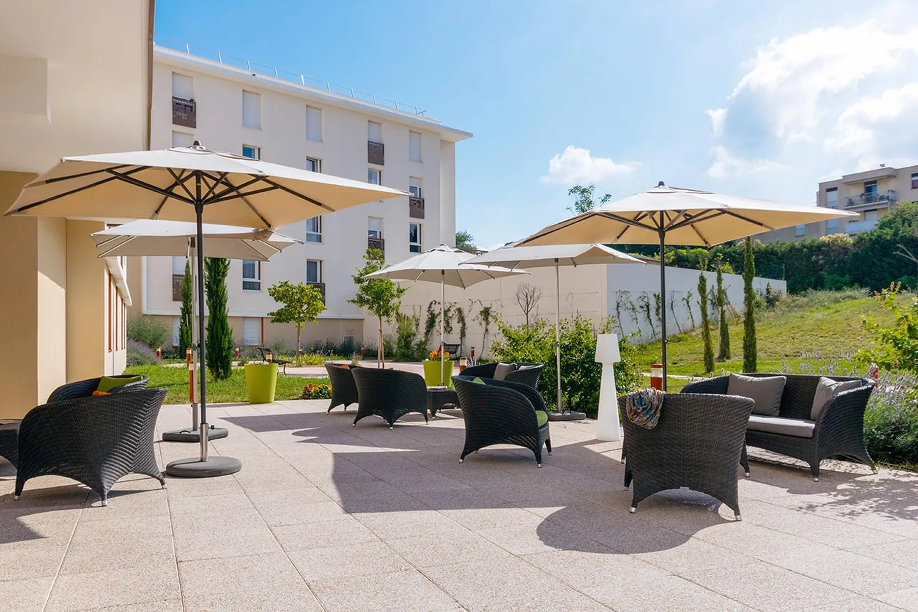 Terrasse jardin avec parasol et salon d'extérieur en ehpad à Marseille, Résidence Val de Regny