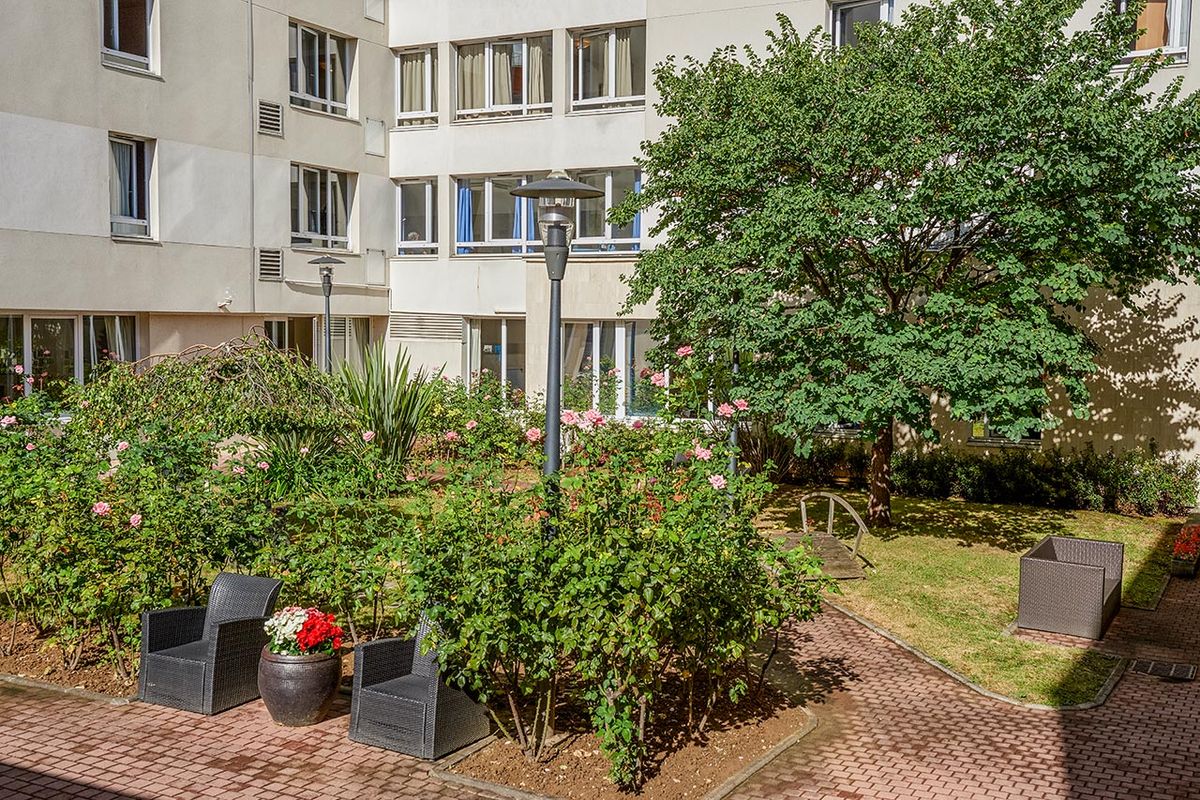 Jardin exterieur avec verdure et buissons, ehpad à asnières
