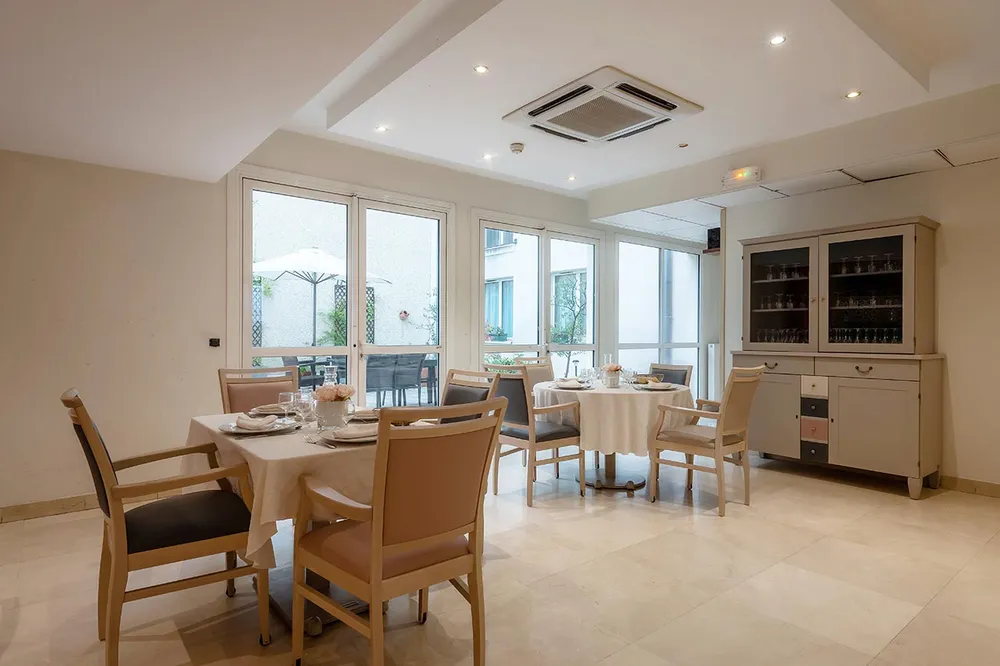 Salle de restaurant avec climatiseur, fenêtre et tables dressé, ehpad à Clichy